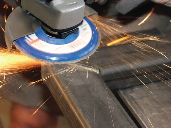 Penggiling sudut memotong logam dengan percikan api beterbangan.