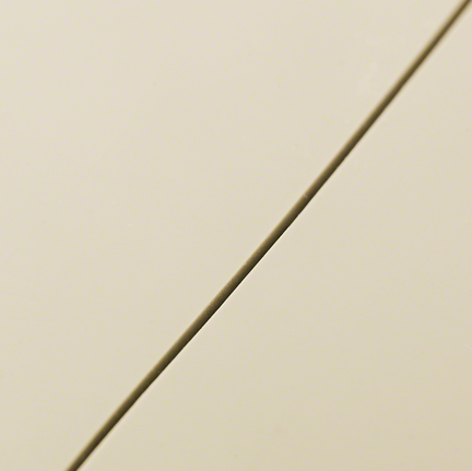 Tampilan dekat garis potong lurus pada ubin krem ​​yang halus.