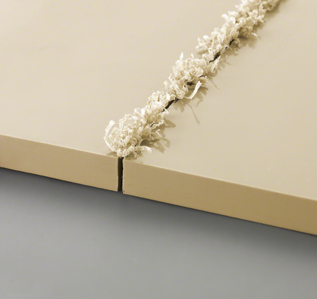 Dua panel berwarna krem ​​dengan potongan alur baru dan serutan kayu melengkung di sepanjang tepinya.