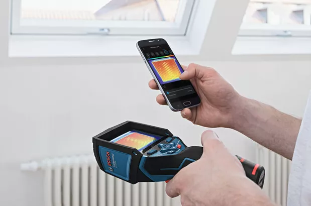 GTC 400 C Seseorang menggunakan kamera termal dan telepon pintar untuk melihat gambar termal di dalam ruangan.