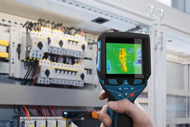 GTC 400 C Seseorang menggunakan kamera termo untuk memeriksa panel listrik untuk mengetahui adanya anomali panas.