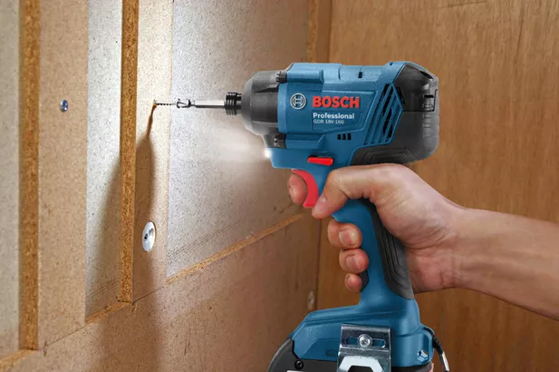 GDR 180-LI Seseorang memasang sekrup ke panel kayu menggunakan obeng benturan tanpa kabel.