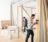 Dua pria membangun tembok kayu.