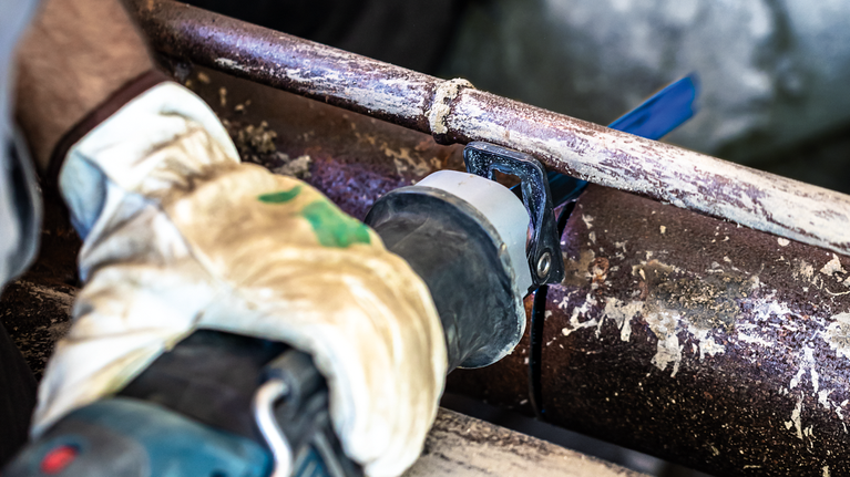 Bilah Gergaji Bolak-Balik S 955 CHC EXPERT 'Thick Tough Metal' 1 buah Seseorang yang mengenakan peralatan keselamatan memotong pipa logam berkarat dengan gergaji bolak-balik.