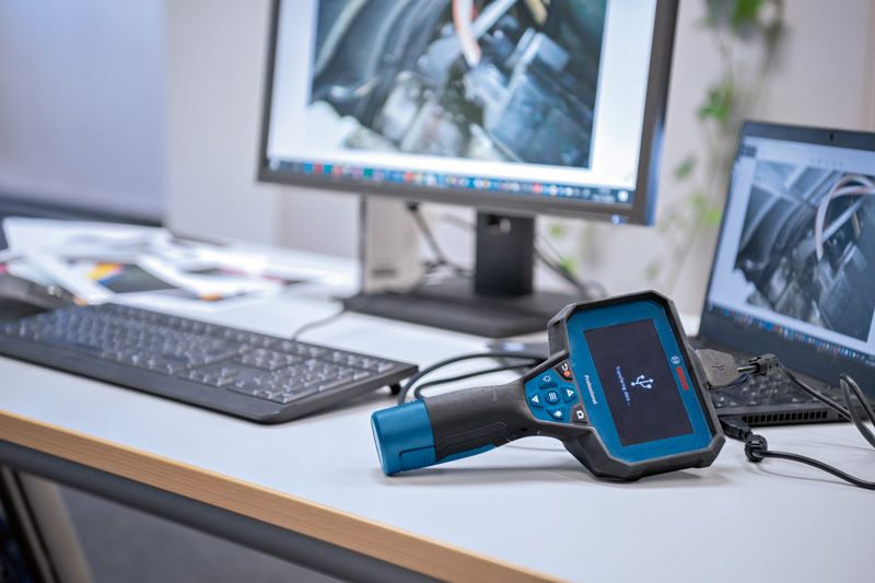 Kamera inspeksi yang terhubung ke komputer di meja kantor menampilkan gambar mesin.