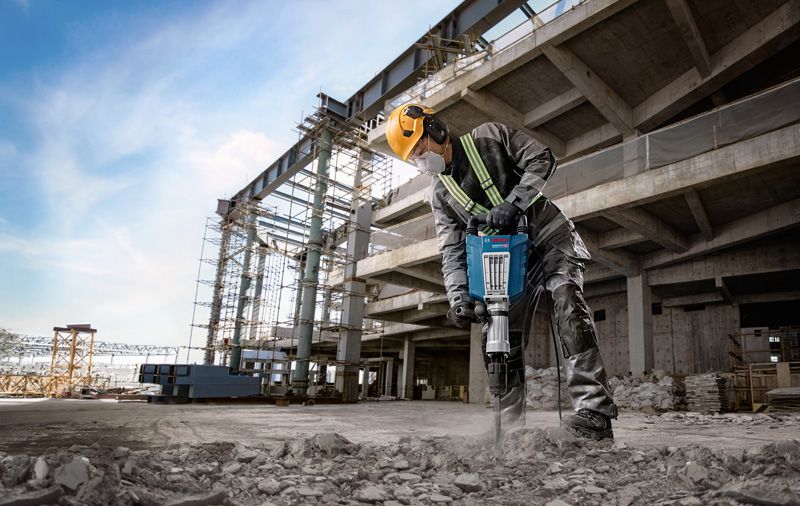 Pekerja menggunakan jackhammer di lokasi.