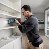 Pemotong multi nirkabel Bosch GOP 185-LI digunakan untuk pemasangan di rak.