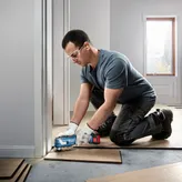 Pemotong multi nirkabel Bosch GOP 185-LI memangkas papan lantai.