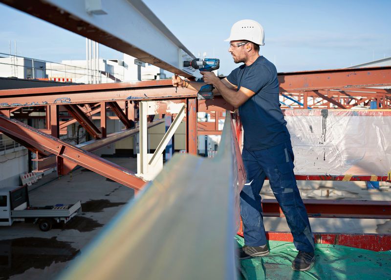 GDS 18V-1600 HC Seseorang yang mengenakan perlengkapan keselamatan menggunakan kunci pas benturan tanpa kabel pada balok baja.