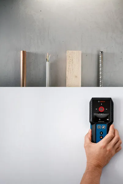 Seseorang menggunakan detektor untuk memindai dinding untuk mencari logam, kayu, dan kabel listrik.