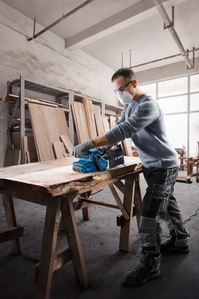 Mesin pengamplas sabuk Bosch GBS 750 menghaluskan papan kayu.