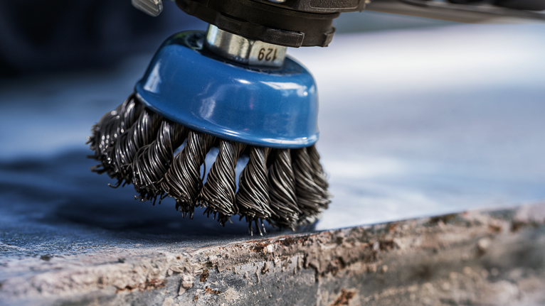 Sikat kawat untuk membersihkan karat dari permukaan logam.