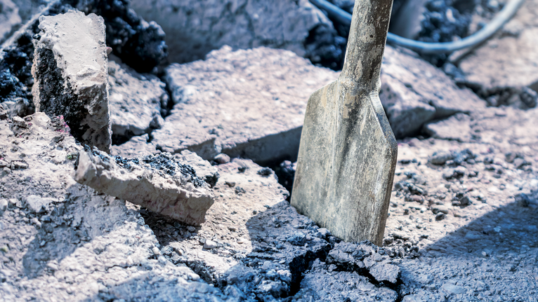 Mata pahat memecah puing beton di lokasi kerja.