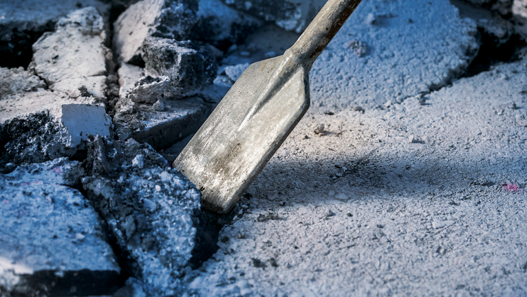 Pahat memecah beton di lokasi konstruksi.