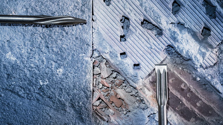 Pahat yang melubangi dinding beton dan bata selama pekerjaan pembongkaran.