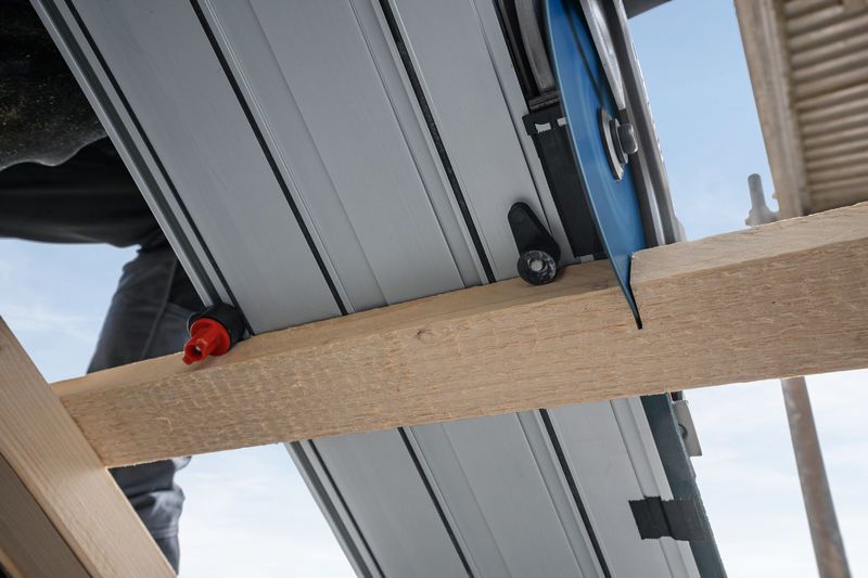 Gergaji lintasan memotong balok kayu di lokasi konstruksi.