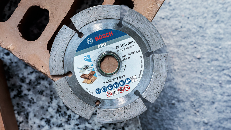 Pisau berlian tersegmentasi untuk memotong batu bata dan beton diletakkan pada balok bangunan.