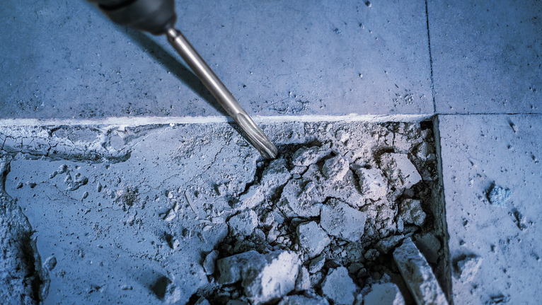 Pahat palu putar memecah lantai beton.