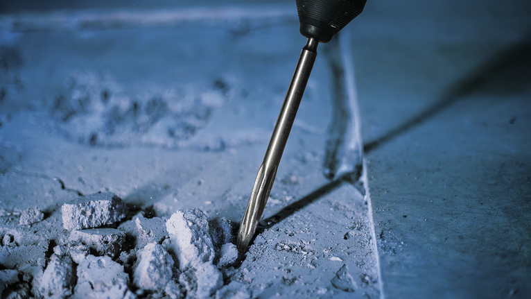 Palu putar yang memecah beton dalam konstruksi.