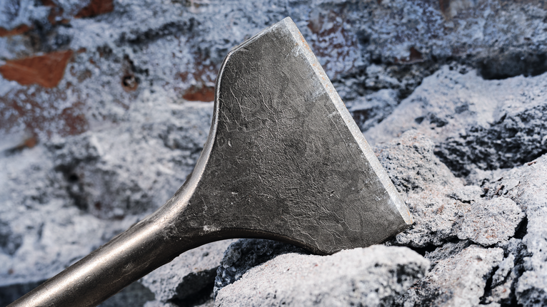 Pahat menembus puing beton kasar.