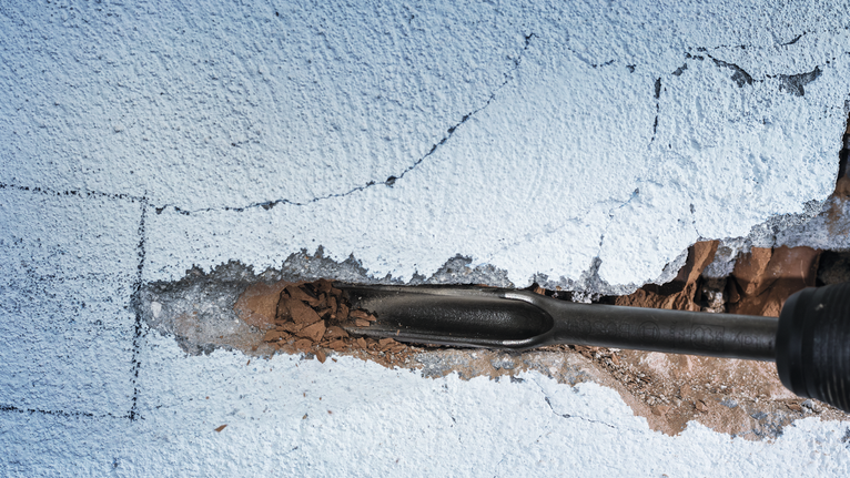 Pahat menghancurkan dinding beton yang retak.