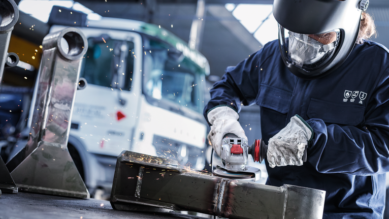 Mata Gerinda Potong Berikat PRO Metal, 125 x 6 x 22,23 mm, X-Lock Orang yang mengenakan peralatan keselamatan menggiling logam, sehingga menimbulkan percikan api.