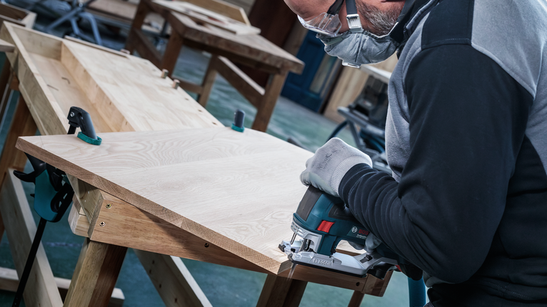 Bilah Gergaji Jigsaw PRO Hardwood clean T101BF, 100 mm, 5 buah Orang yang mengenakan peralatan keselamatan menggunakan gergaji ukir untuk memotong papan kayu.