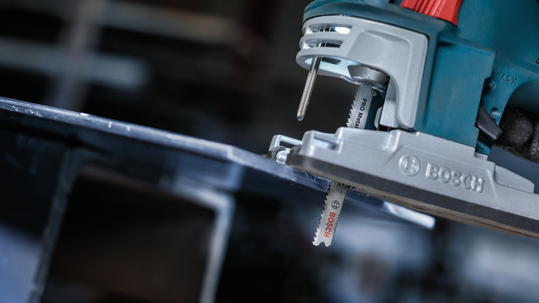 Gergaji ukir memotong lembaran logam di bengkel.