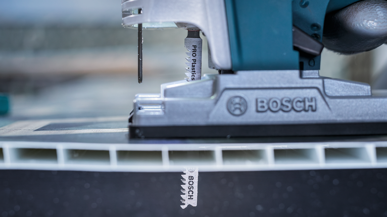 Bilah Gergaji Jigsaw PRO Plastics PVC clean T102H, 100 mm, 2 buah Gergaji ukir memotong panel plastik tebal dalam adegan bengkel jarak dekat.