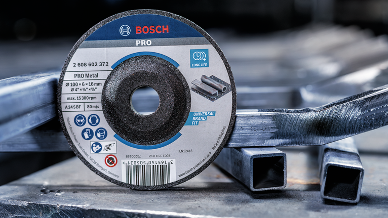 Cakram pemotong diletakkan pada tabung persegi logam bertumpuk dalam lingkungan industri.