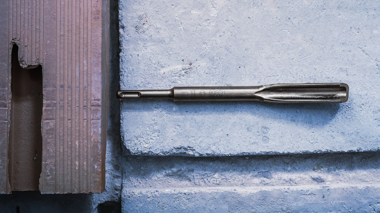 Chisel PRO SDS plus Hollow Gouging, 22 x 250 mm Mata bor pahat ditempatkan pada permukaan blok beton.