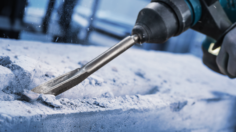 Chisel PRO SDS plus Hollow Gouging, 22 x 250 mm Orang yang mengenakan peralatan keselamatan menggunakan palu putar untuk memahat beton.