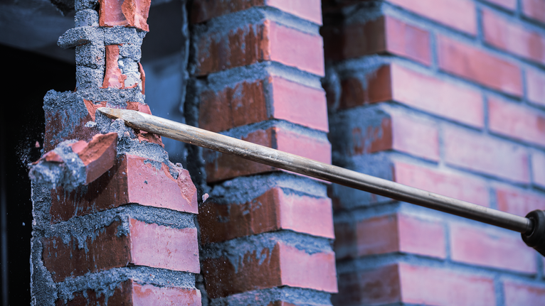 Alat pahat untuk memecahkan dinding bata merah selama pembongkaran.