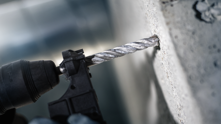 Bor palu membuat lubang di dinding beton.