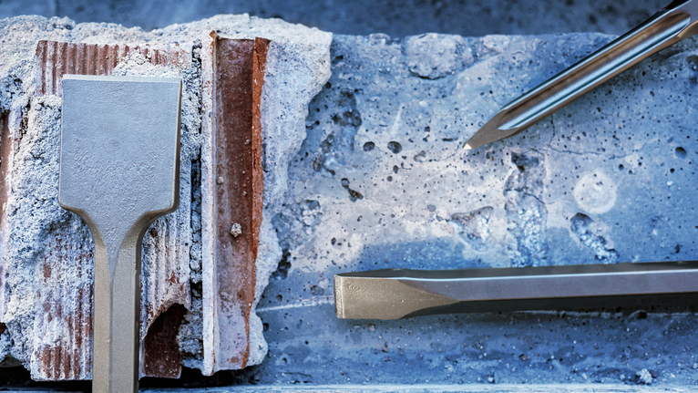 Pahat ditempatkan pada permukaan beton dengan pecahan bata dan serpihan semen.