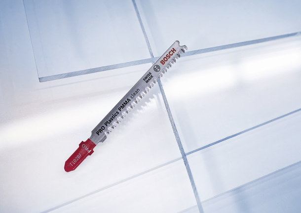 Mata gergaji ukir untuk memotong lembaran plastik pada permukaan kerja yang bening.