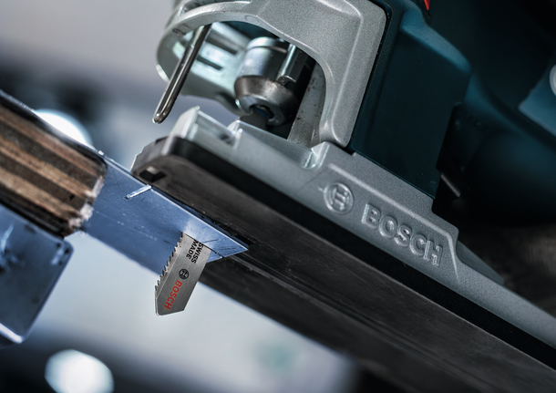 Gergaji ukir memotong lembaran logam dalam tampilan jarak dekat.