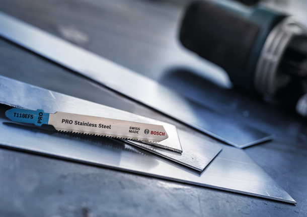 Mata gergaji ukir diletakkan pada lembaran baja tahan karat di bengkel.