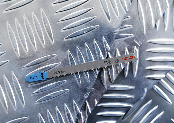 Mata gergaji ukir pada lembaran logam berpola berlian.
