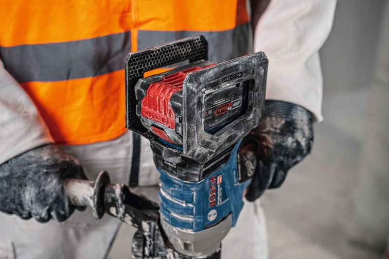 Seseorang yang mengenakan perlengkapan keselamatan mengoperasikan mekanisme pengadukan tanpa kabel.