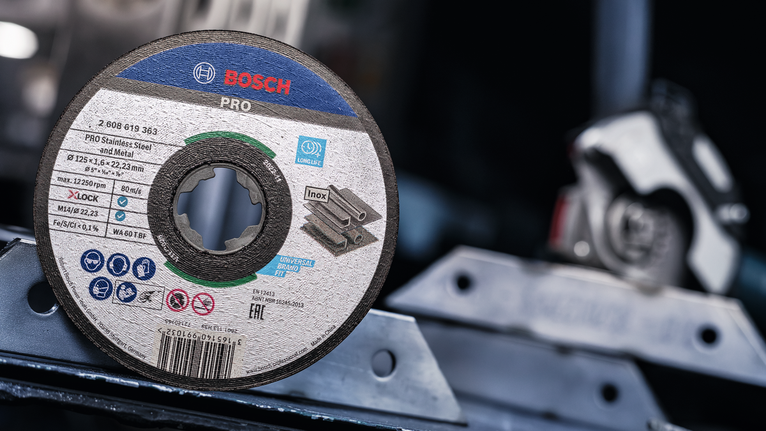 Cakram pemotong untuk baja tahan karat ditempatkan pada permukaan logam di bengkel.