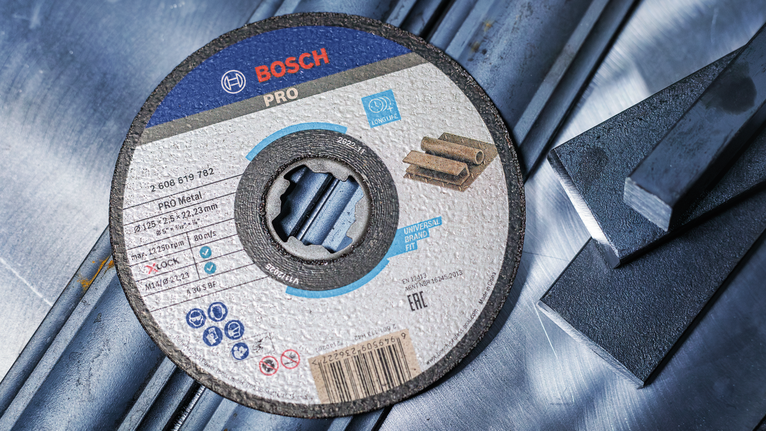 Cakram pemotong untuk logam diletakkan pada batang baja.