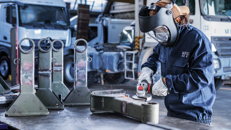 Mata Gerinda Potong Berikat PRO Metal, 125 x 6 x 22,23 mm, X-Lock Orang yang mengenakan perlengkapan keselamatan menggiling bagian logam di lingkungan industri.