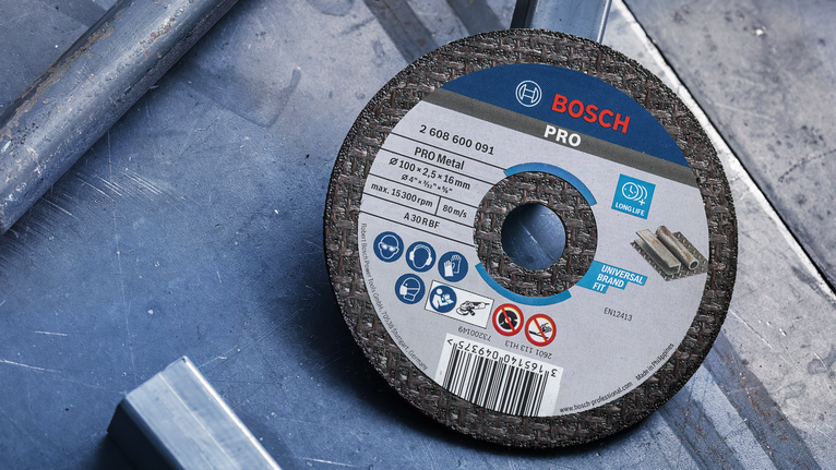 Cakram pemotong logam ditempatkan pada permukaan logam di bengkel.