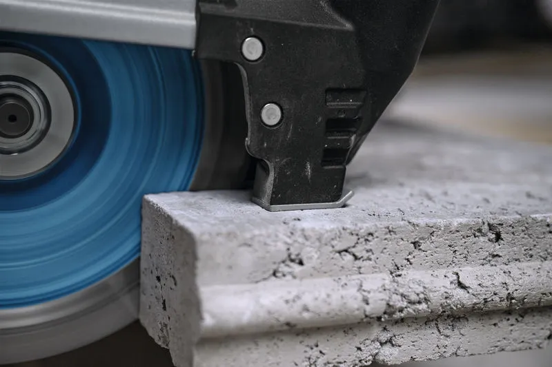 Penggiling sudut besar memotong lempengan beton tebal.