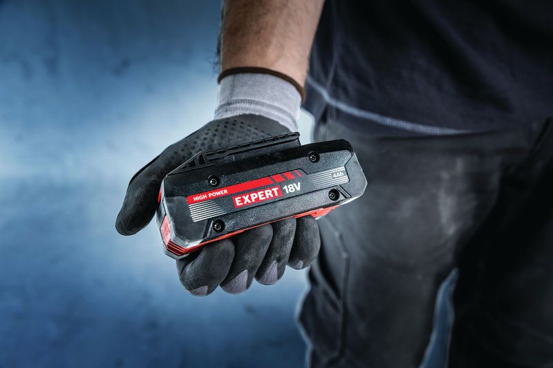 Baterai Bosch Expert 18V dipegang dengan tangan yang bersarung tangan.