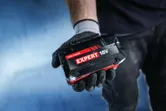 Baterai Bosch Expert 18V di tangan yang bersarung tangan.