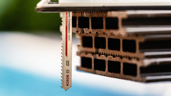 Mata gergaji ukir memotong material komposit berongga yang ditumpuk.