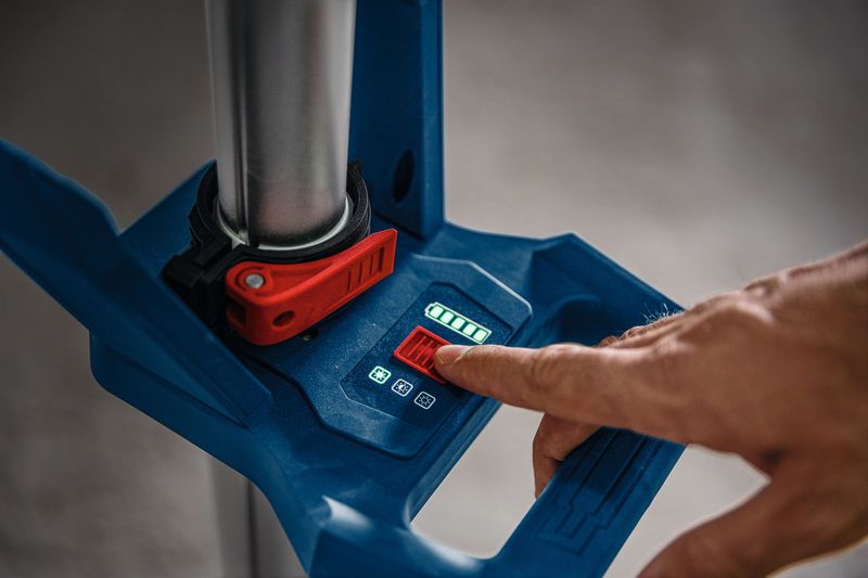 Seseorang mengatur lampu lokasi kerja tanpa kabel menggunakan panel kontrol digital.