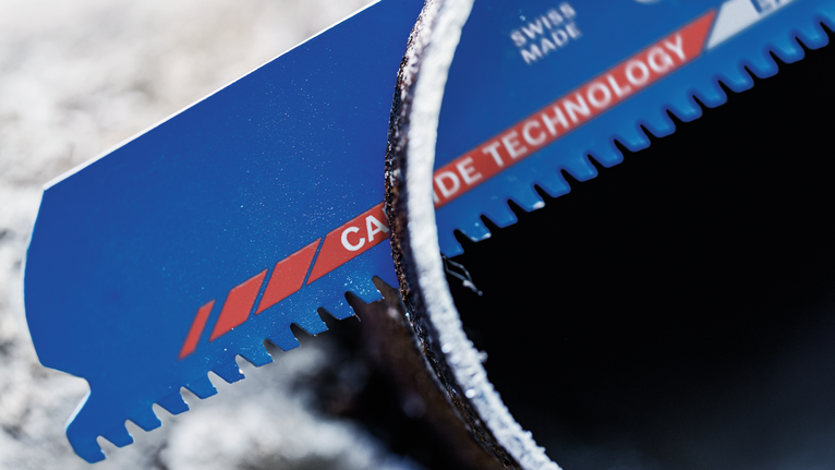 Mata gergaji dengan gigi karbida memotong pipa logam.